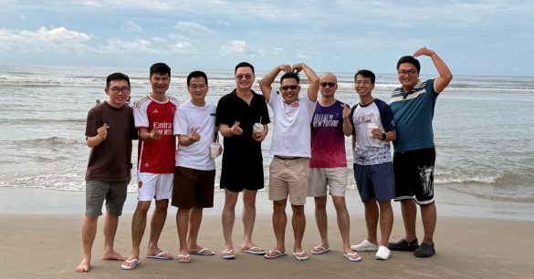 Thành viên Cộng đồng Lãnh Đạo Số chụp ảnh nhóm trên bãi biển trong buổi team building