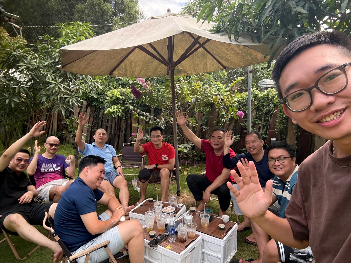 Thành viên Cộng đồng Lãnh Đạo Số trò chuyện thân mật dưới ô dù trong vườn, buổi team building