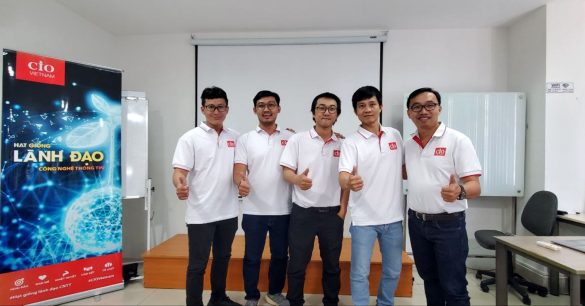 Nhóm năm học viên mùa 8 TP.HCM giơ ngón cái bên standee chương trình trong buổi học BRM & Leadership