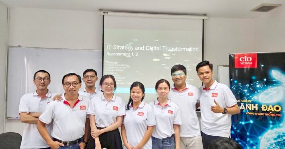 Nhóm học viên mùa 8 TP.HCM chụp ảnh chung trước màn chiếu IT Strategy and Digital Transformation – Assessment 1, 2