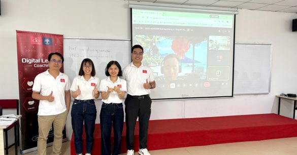 Nhóm bốn học viên Digital Leaders Coaching SS10 TP.HCM giơ ngón cái trước màn chiếu trong buổi học BRM & Leadership, bên standee chương trình