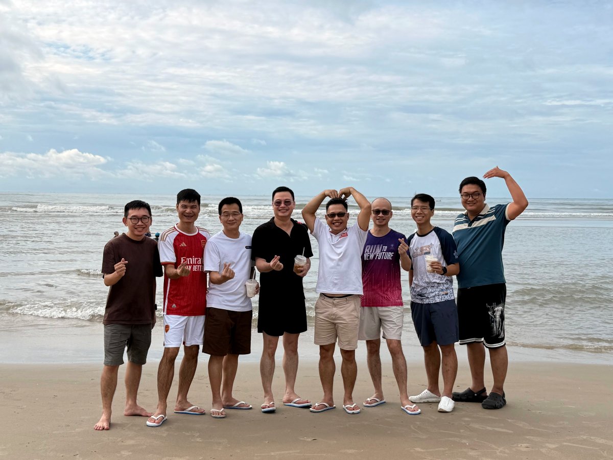 Ban huấn luyện Digital Leaders Coaching chụp ảnh cùng nhau bên bờ biển trong chuyến Team Building