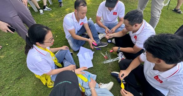Một nhóm học viên Digital Leaders Coaching SS10 TP.HCM ngồi trên bãi cỏ cùng giải thử thách đội nhóm trong ngày Retreat