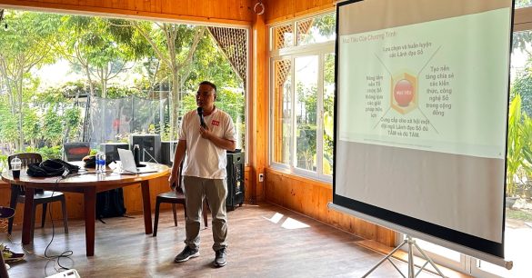 Một thành viên Digital Leaders Coaching chia sẻ trước màn chiếu trong ngày Retreat của lớp SS10 TP.HCM