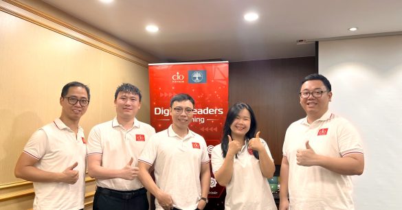 Nhóm năm học viên Digital Leaders Coaching SS10 Hà Nội giơ ngón cái bên standee chương trình trong buổi học Personal Branding