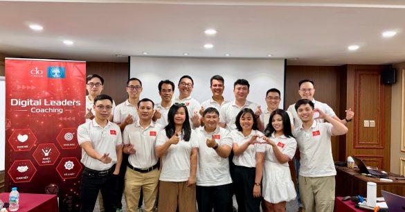 Ảnh tập thể học viên Digital Leaders Coaching SS10 Hà Nội bên standee chương trình trong buổi học BRM & Leadership