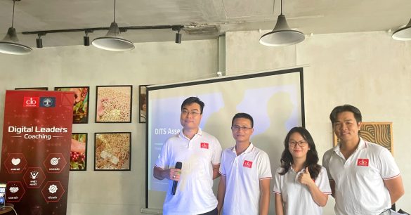 Nhóm bốn học viên Digital Leaders Coaching SS10 TP.HCM thuyết trình trước màn chiếu trong buổi học Digital & IT Strategy, bên standee chương trình