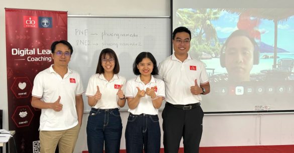 Nhóm học viên Digital Leaders Coaching SS10 TP.HCM chụp ảnh cùng một học viên tham gia trực tuyến trên màn chiếu