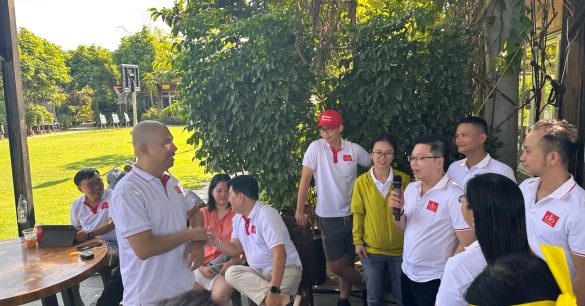 Các thành viên Digital Leaders Coaching SS10 TP.HCM đứng quây quần lắng nghe chia sẻ ngoài trời trong ngày Retreat