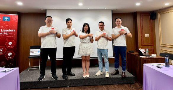 Một nhóm năm học viên Digital Leaders Coaching SS10 Hà Nội đứng trên sân khấu sau phần trình bày trong buổi học BRM & Leadership